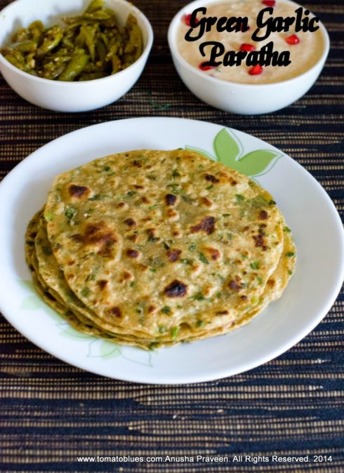 green garlic parathas stacked and served on a white plate