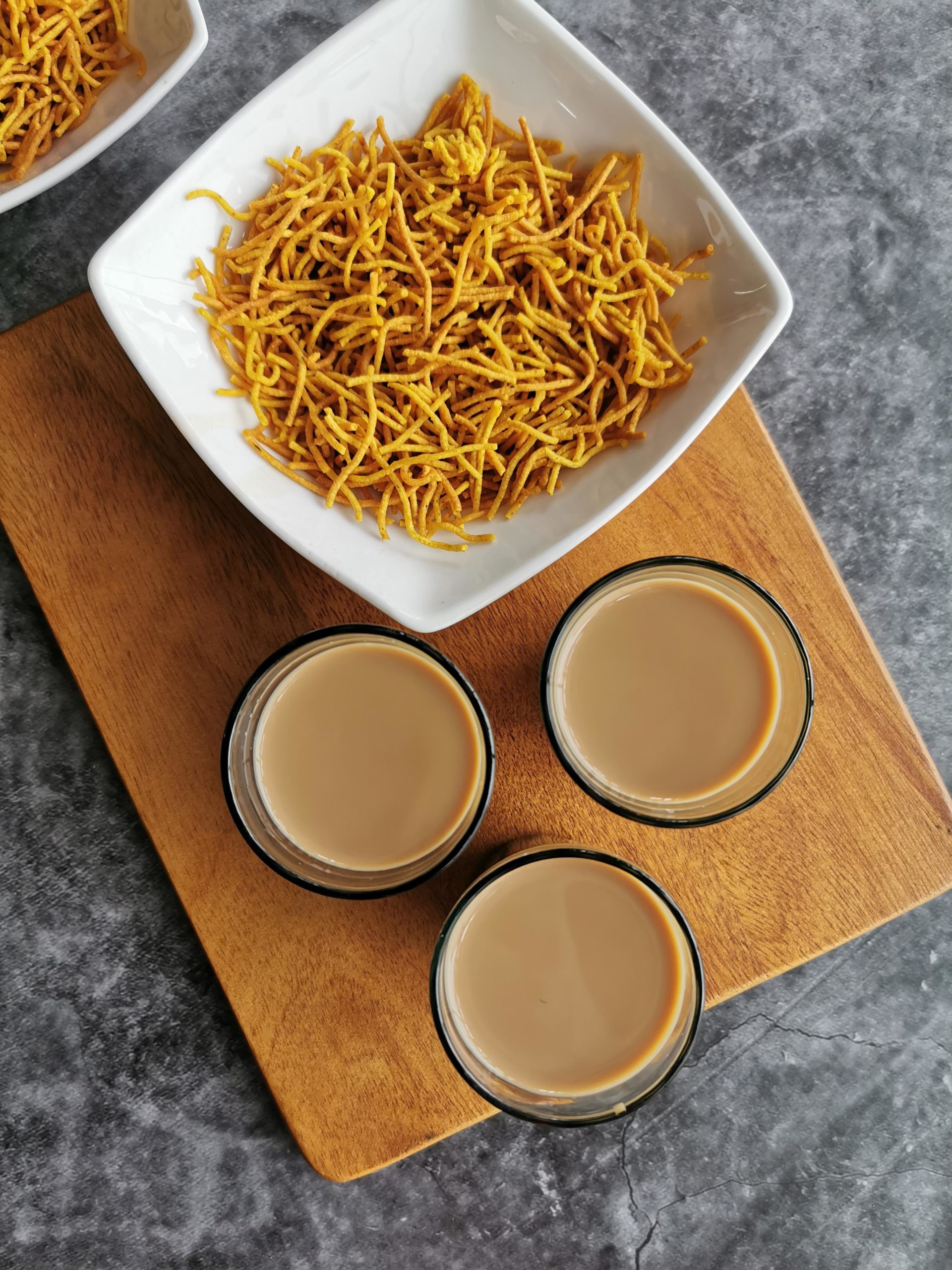 Aloo Bhujia- Potato sev served in white bowls with chai