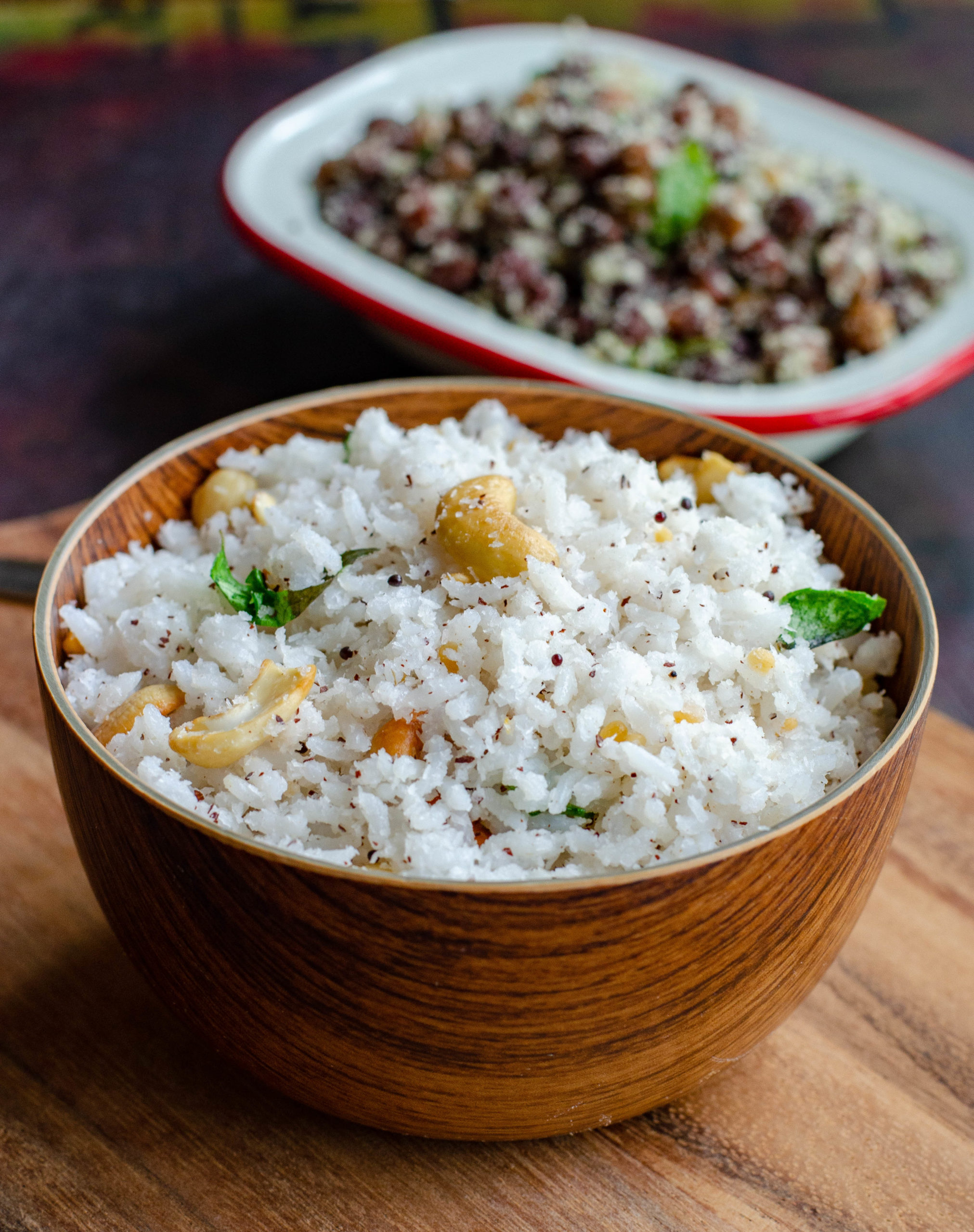Thengai Sadam, south Indian style coconut rice served along with Kaala channa stir fry. Both placed at an angle to each other on a wooden chopping board.