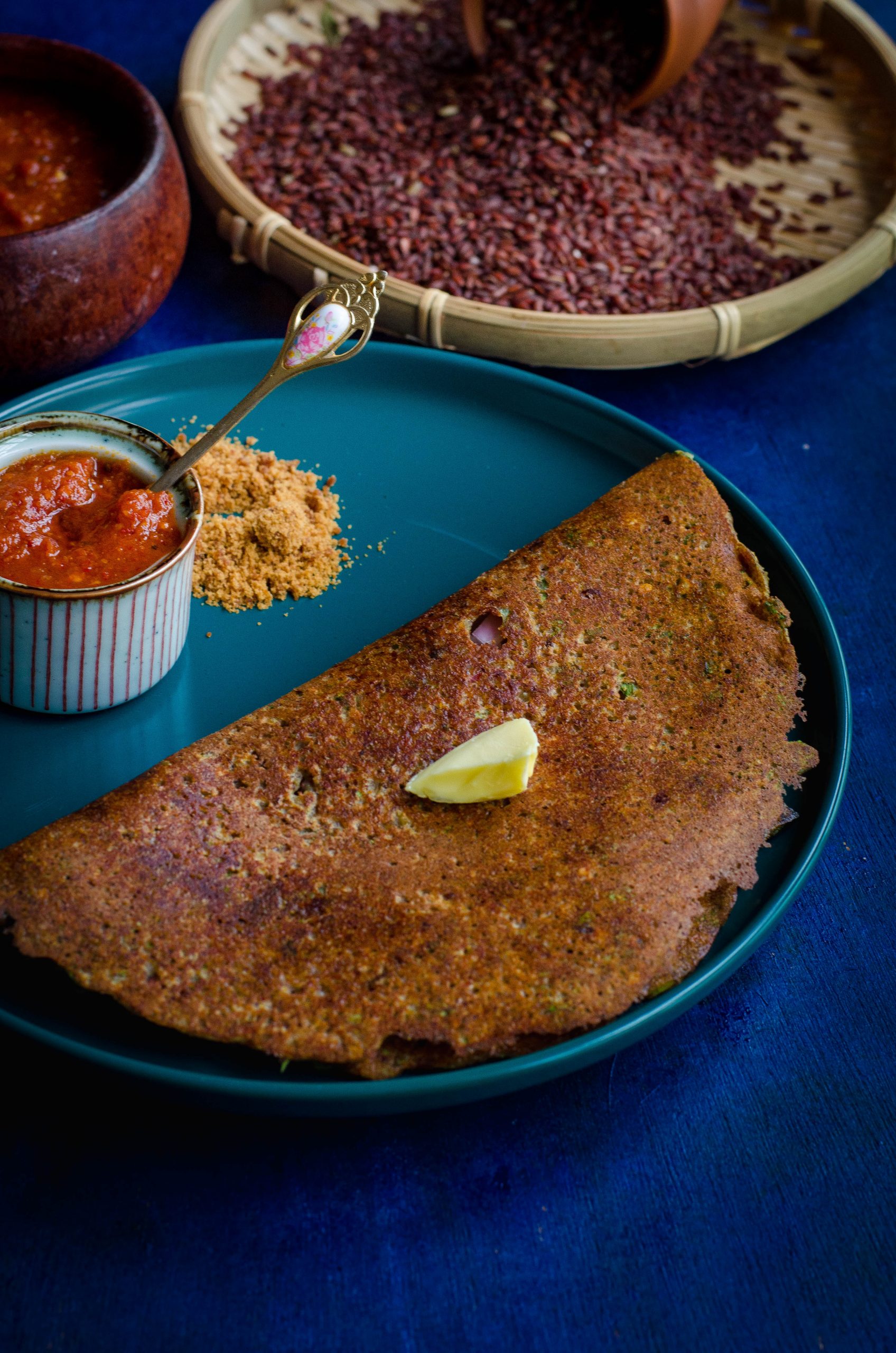 mapillai samba adai served on a turquoise blue plate against a blue backdrop