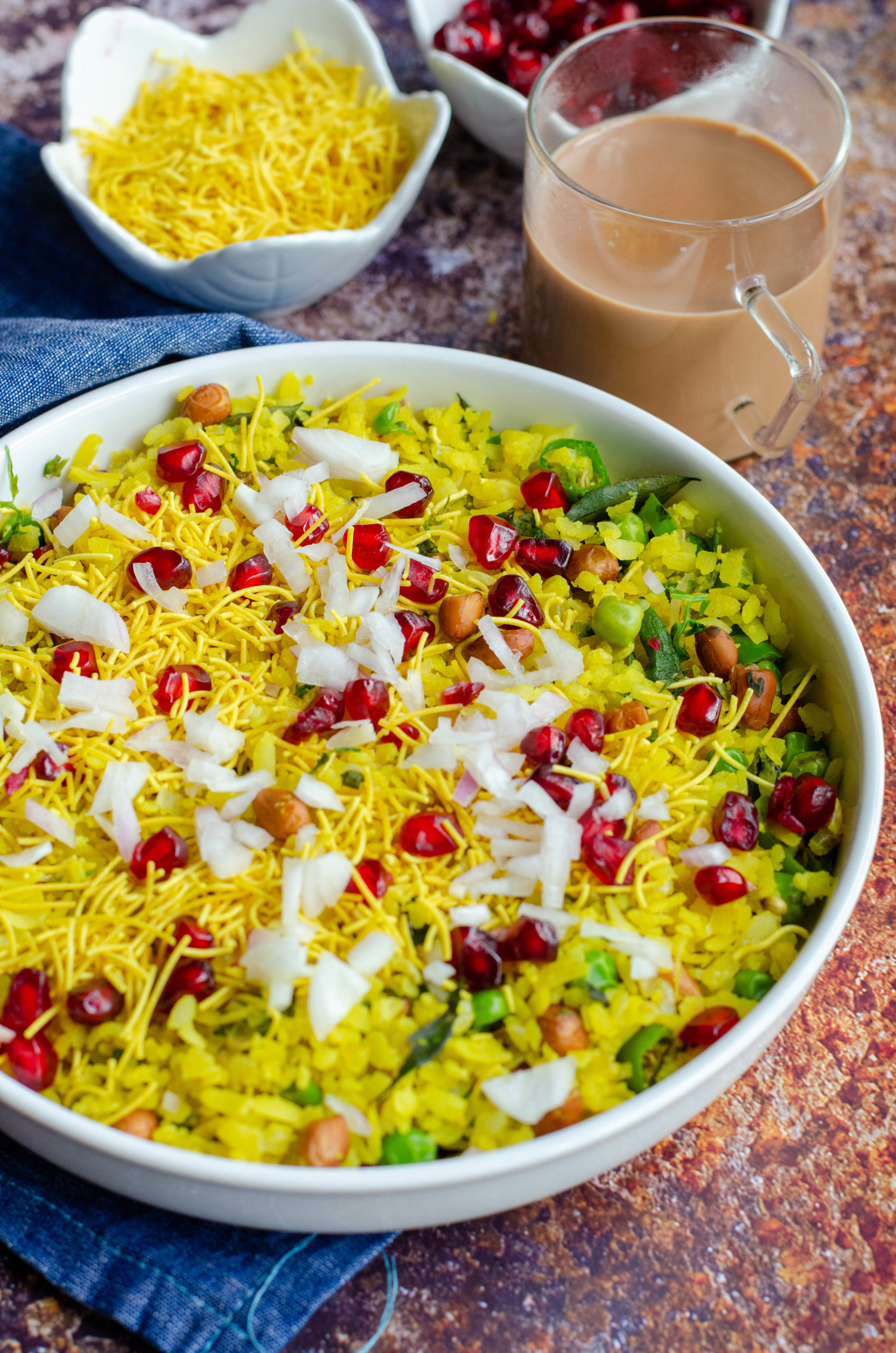 kanda batata poha served in a white bowl with chai