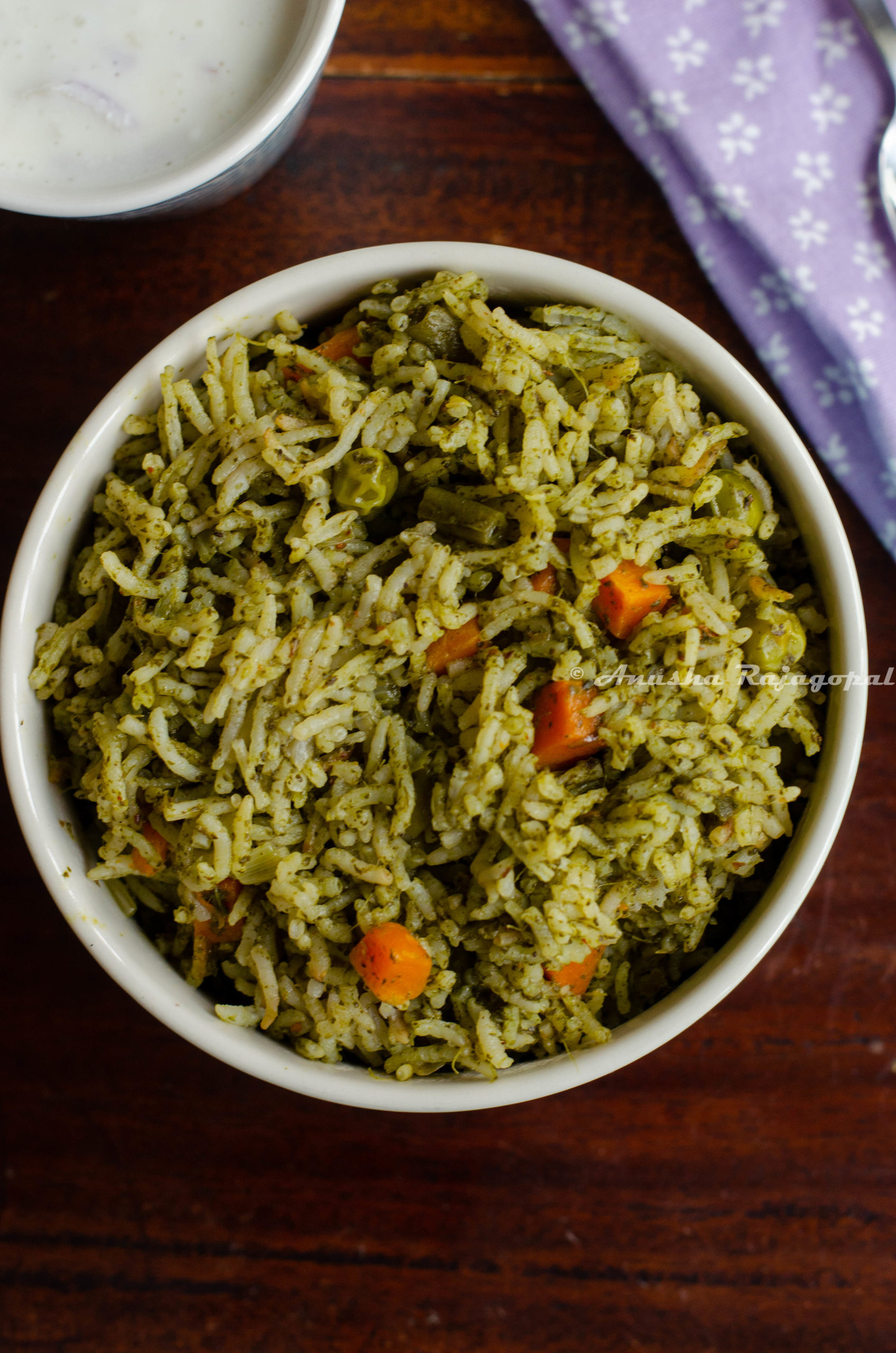 spinach pulao made in the instant pot and served in a blue bowl with raita 