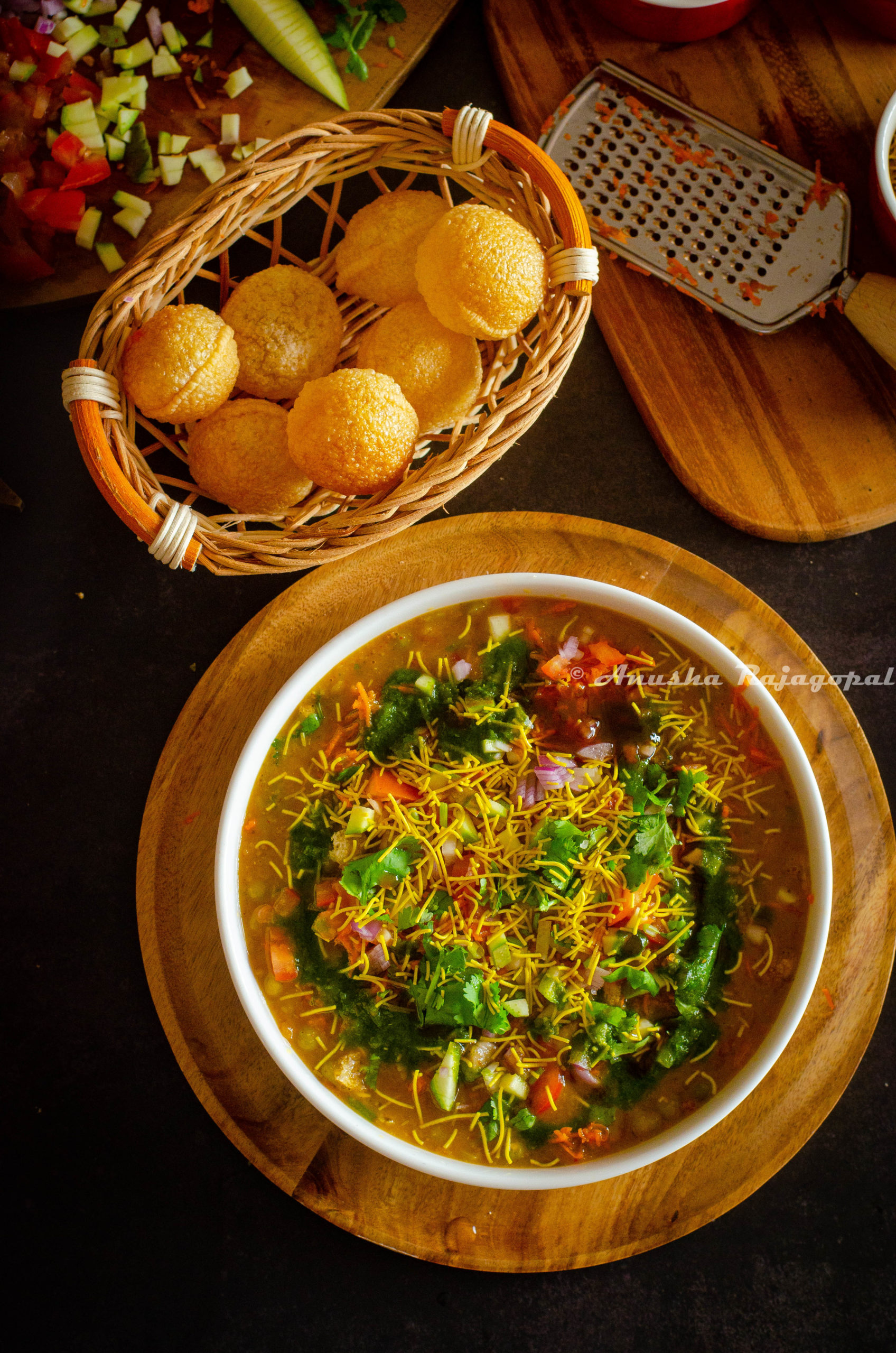 Bangalore style Masala Puri served in a white bowl with fried Pooris and chopped veggies beside the bowl.