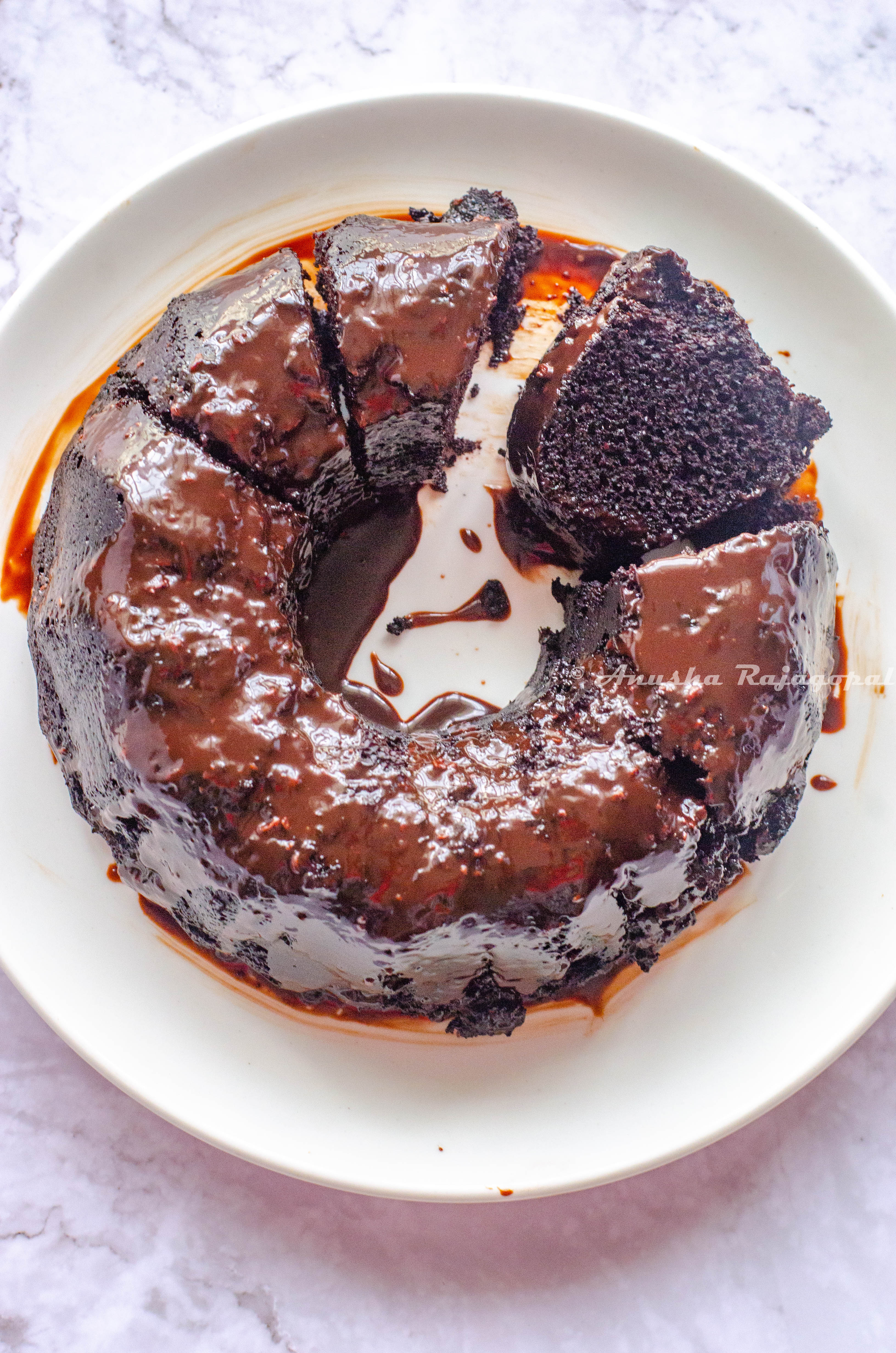 black magic cake glazed and sliced . served on a white plate 