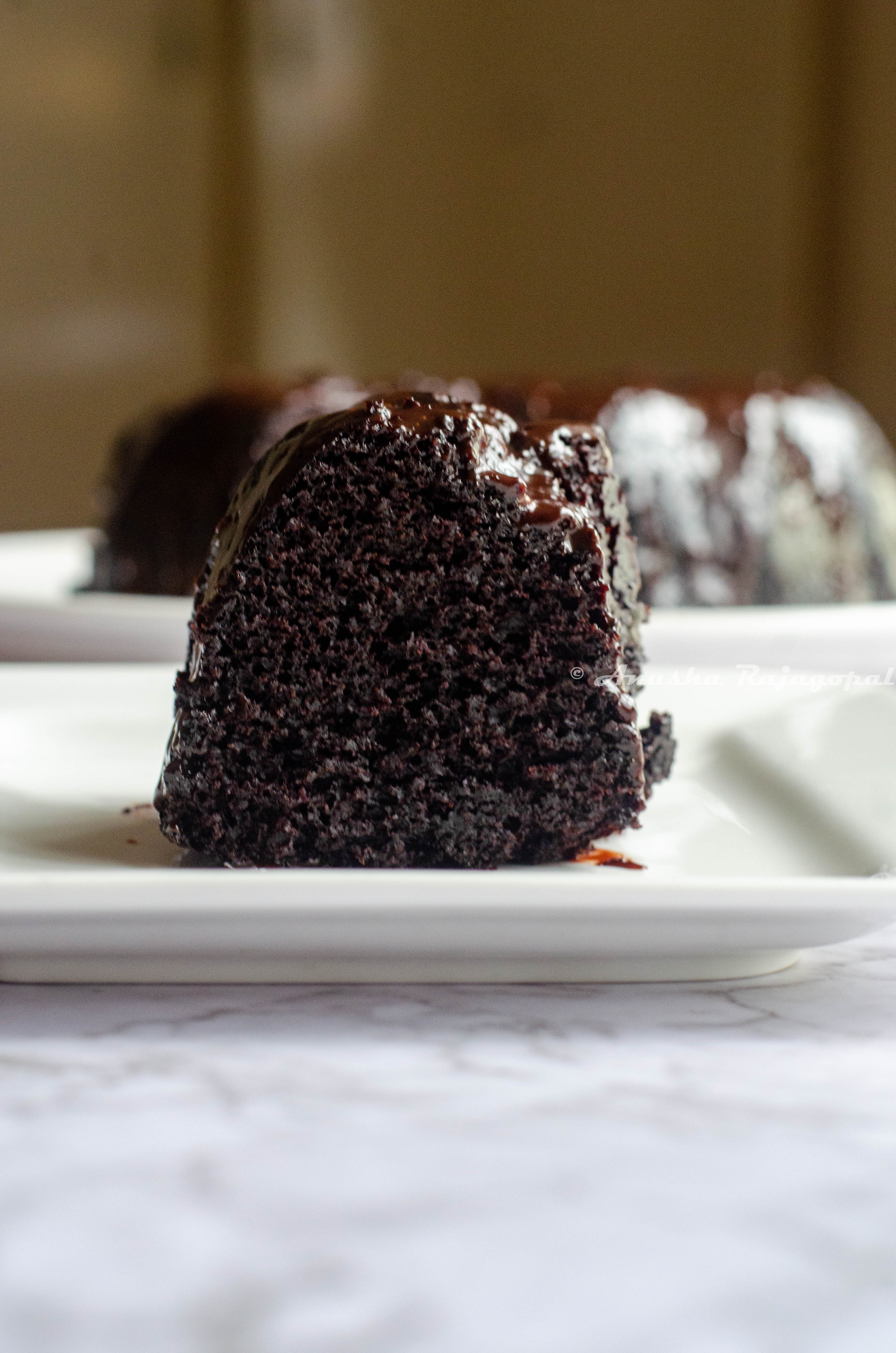 black magic cake glazed and sliced . served on a white plate