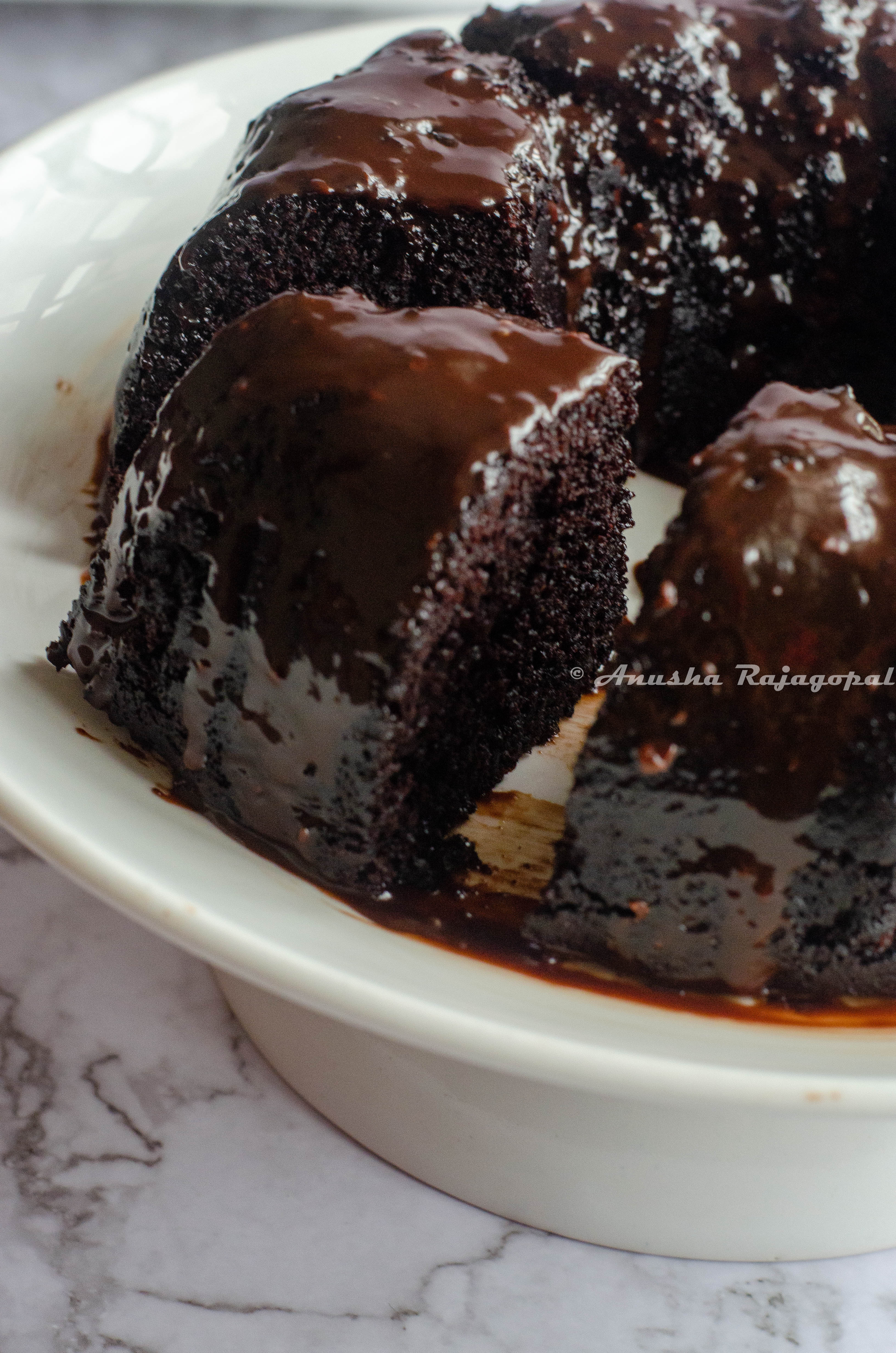 black magic cake glazed and sliced . served on a white plate