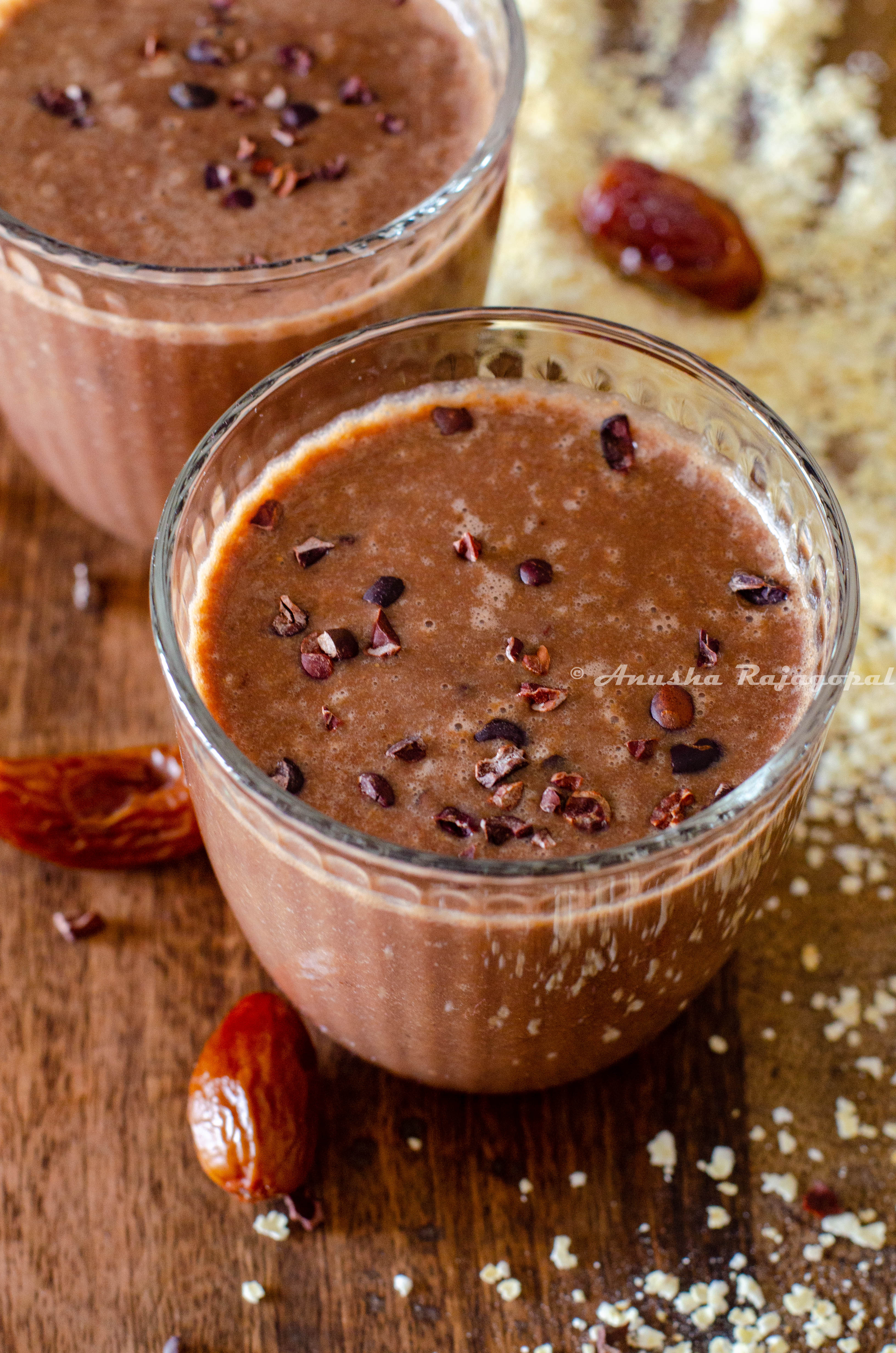 vegan coffee banana smoothie topped with cacao nibs and served in glasses 