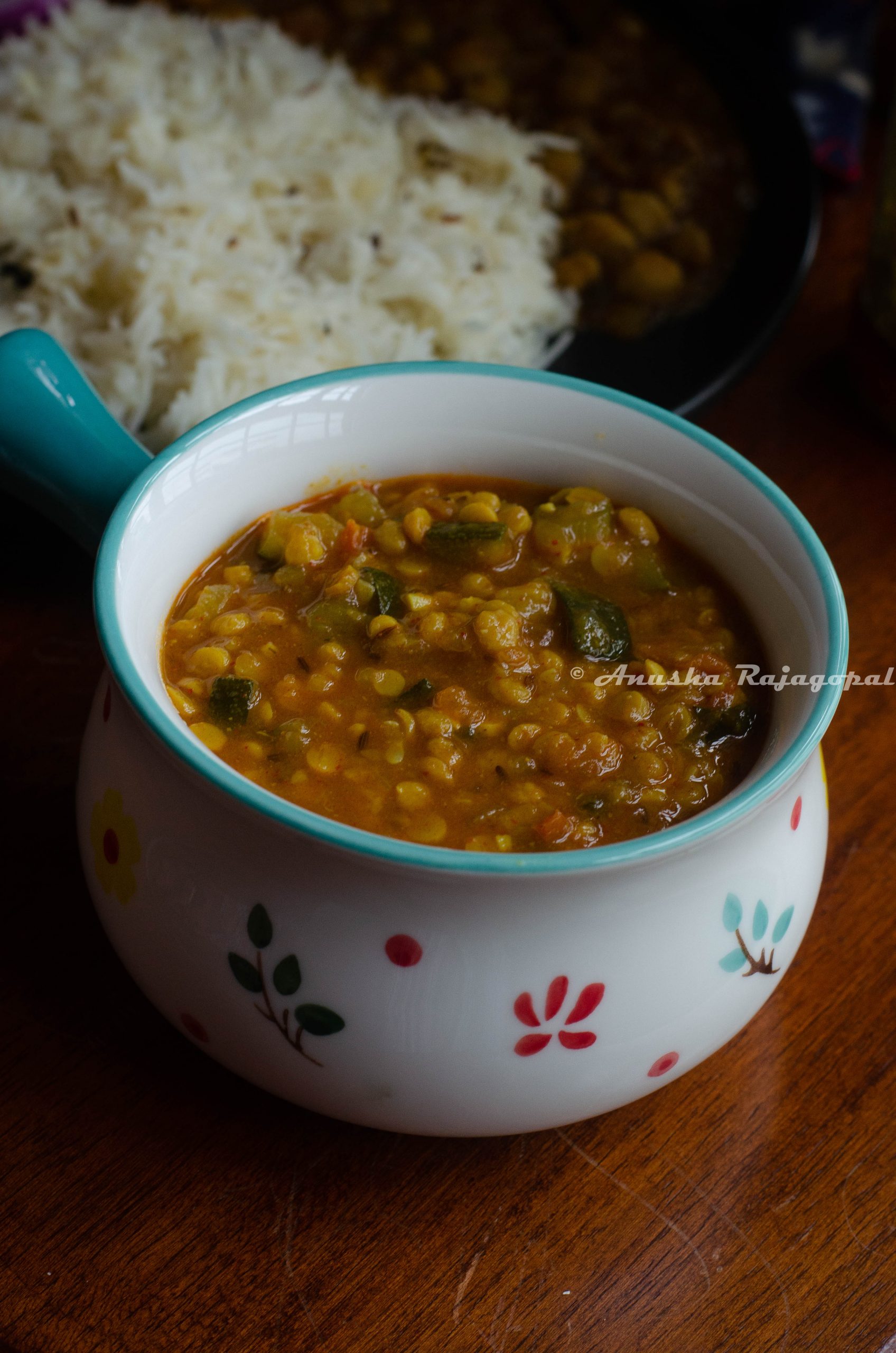 Instant pot zucchini channa dal served in a white bowl with a blue handle.