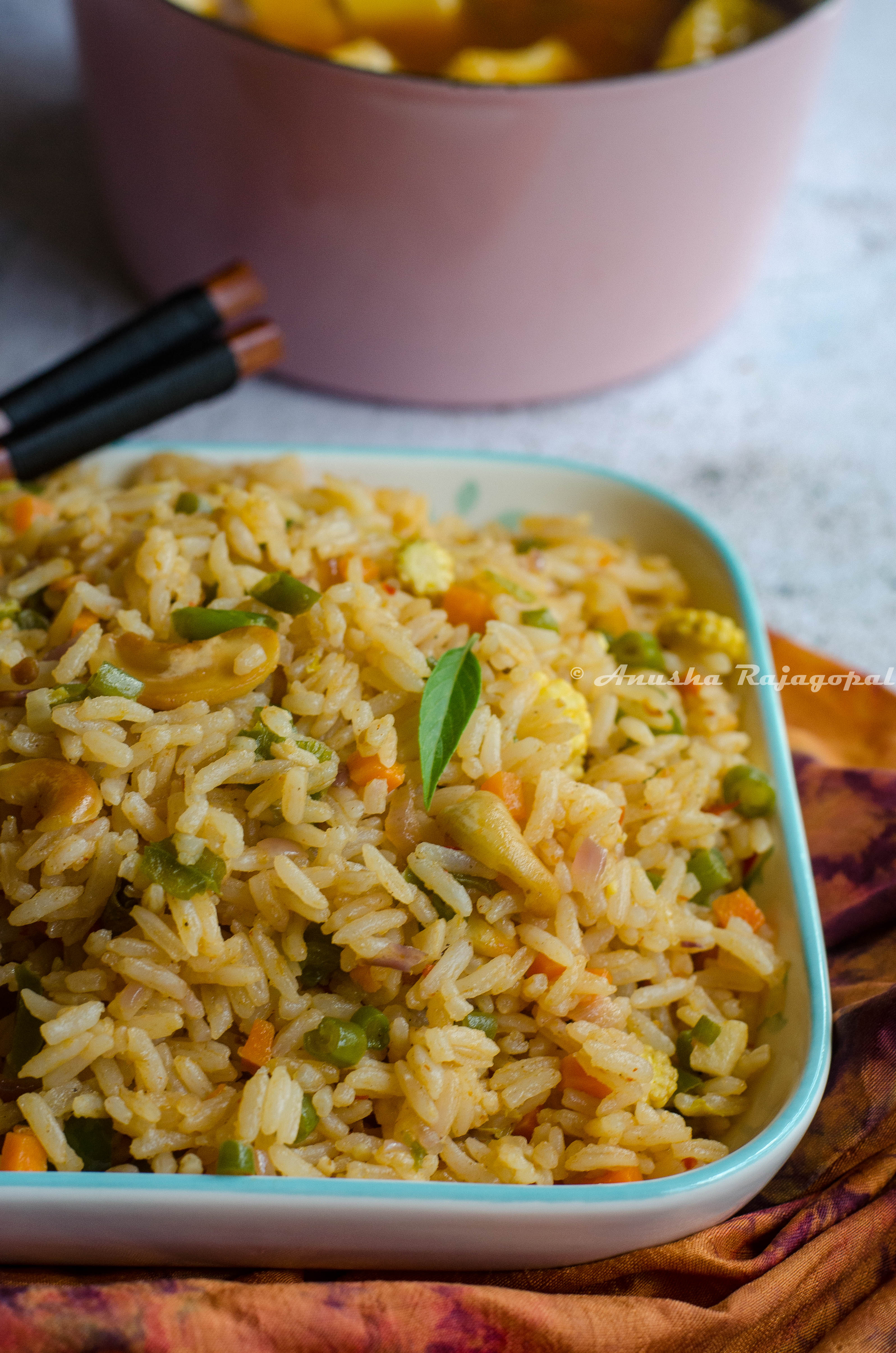 vegan thai basil fried rice served in a white platter placed on a tye dye napkin