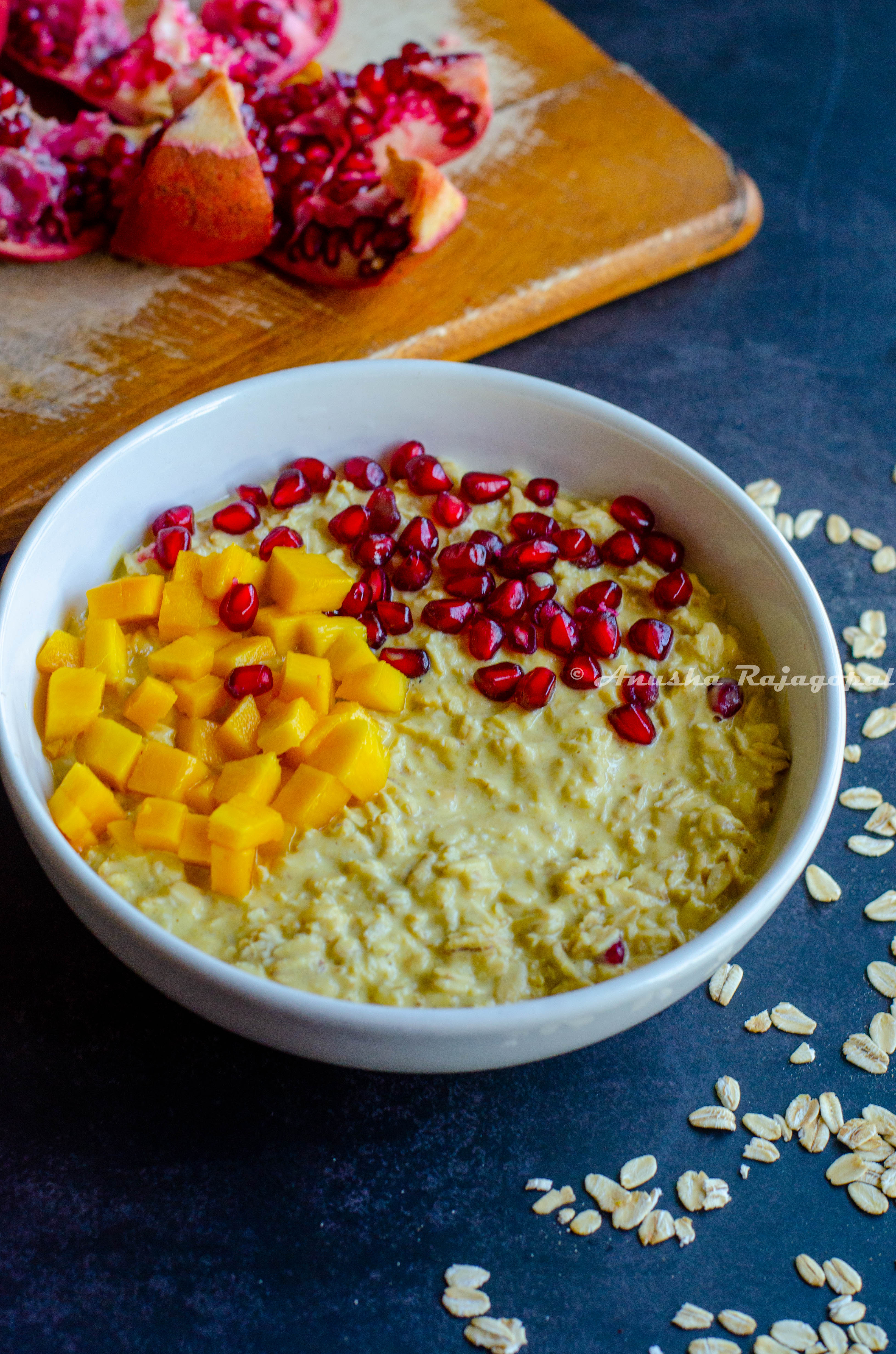 vegan mango overnight oats topped with pomegranate pearls and mangoes